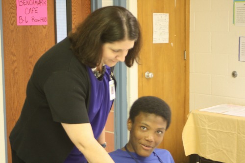 Ms. Hamby stops to help student Michael DeNato. They are working hard on algebraic equations.