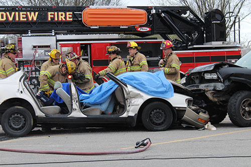 Members of the Grandview Fire Department work the scene of a staged traffic accident at Grandview High School. The mock crash was designed to remind students of the dangers of distracted driving.